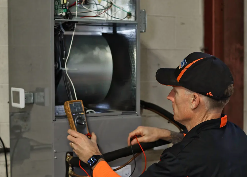 Perfect Timing Heating & Cooling technician performing heating services and diagnostic testing on a residential heating system to ensure dependable indoor comfort