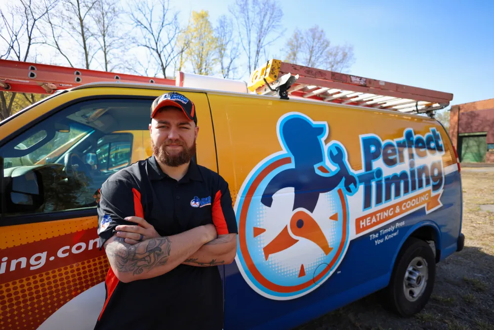 Perfect Timing Heating & Cooling emergency HVAC technician standing beside a branded service vehicle ready to provide fast heating and cooling repairs