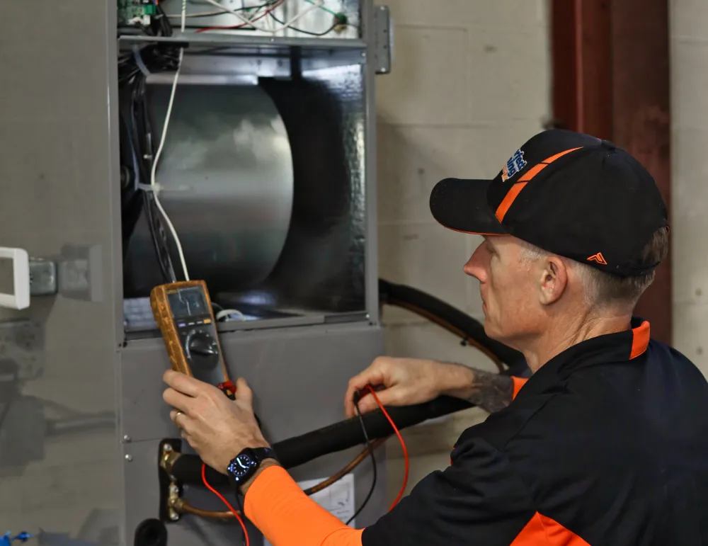 Perfect Timing Heating & Cooling technician performing furnace maintenance and system testing to improve heating efficiency and reliability